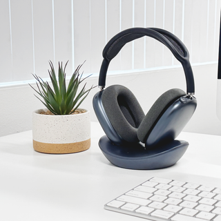 Macally AirPods Max charging stand in midnight - on a desk with a plant and keyboard