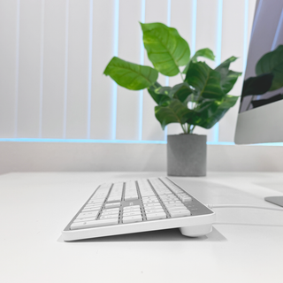 Macally wired keyboard and mouse combo for Mac in Silver - keyboard on a desk next to an iMac