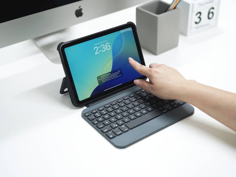 Person using Macally iPad Mini keyboard case at a modern desk setup