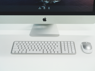 Sleek iMac setup with white keyboard and silver Macally mouse on a bright minimalist desk